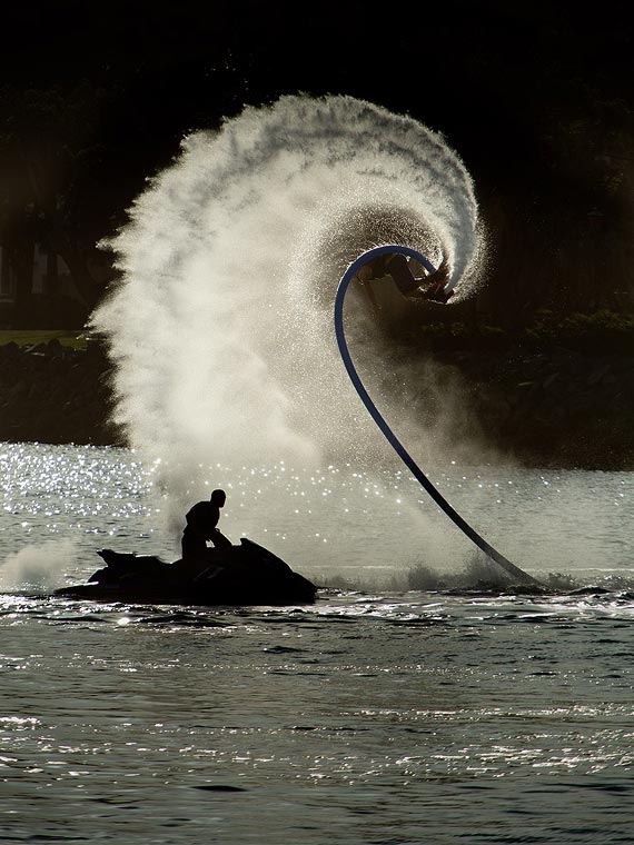 Man performing an outside loop with a water-propelled board