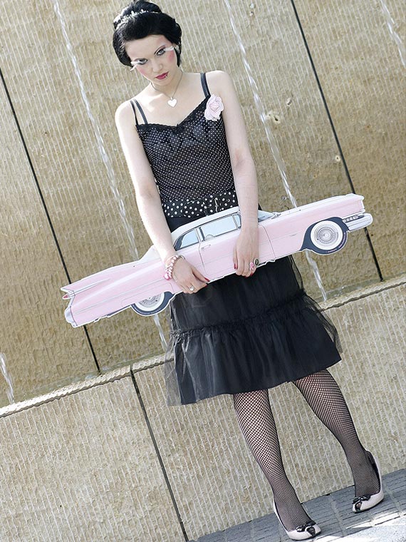 Girl in Fifties-style with pink Cadillac